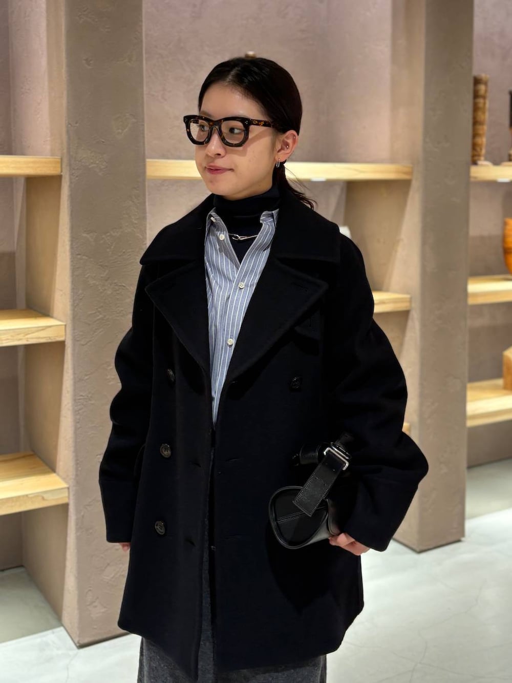 ブルー系のニット/セーター、ブルー系のシャツ/ブラウス、ブルー系のピーコートを着用したレディースの秋コーディネートの6枚目の写真