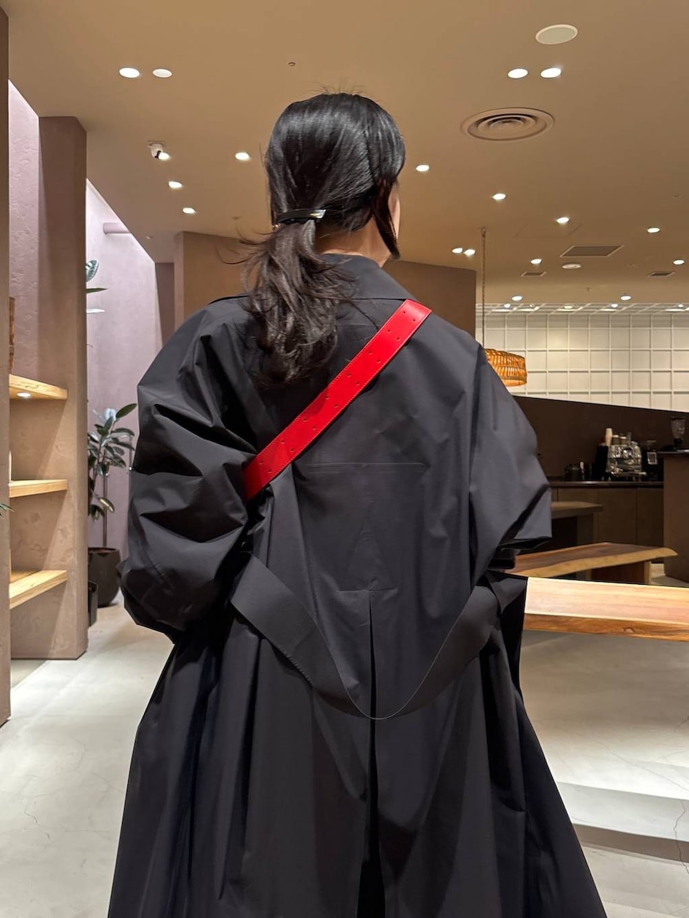 グレー系のスラックス、ホワイト系のカーディガン/ボレロ、ブラック系のトレンチコートを着用したレディースの冬コーディネートの5枚目の写真