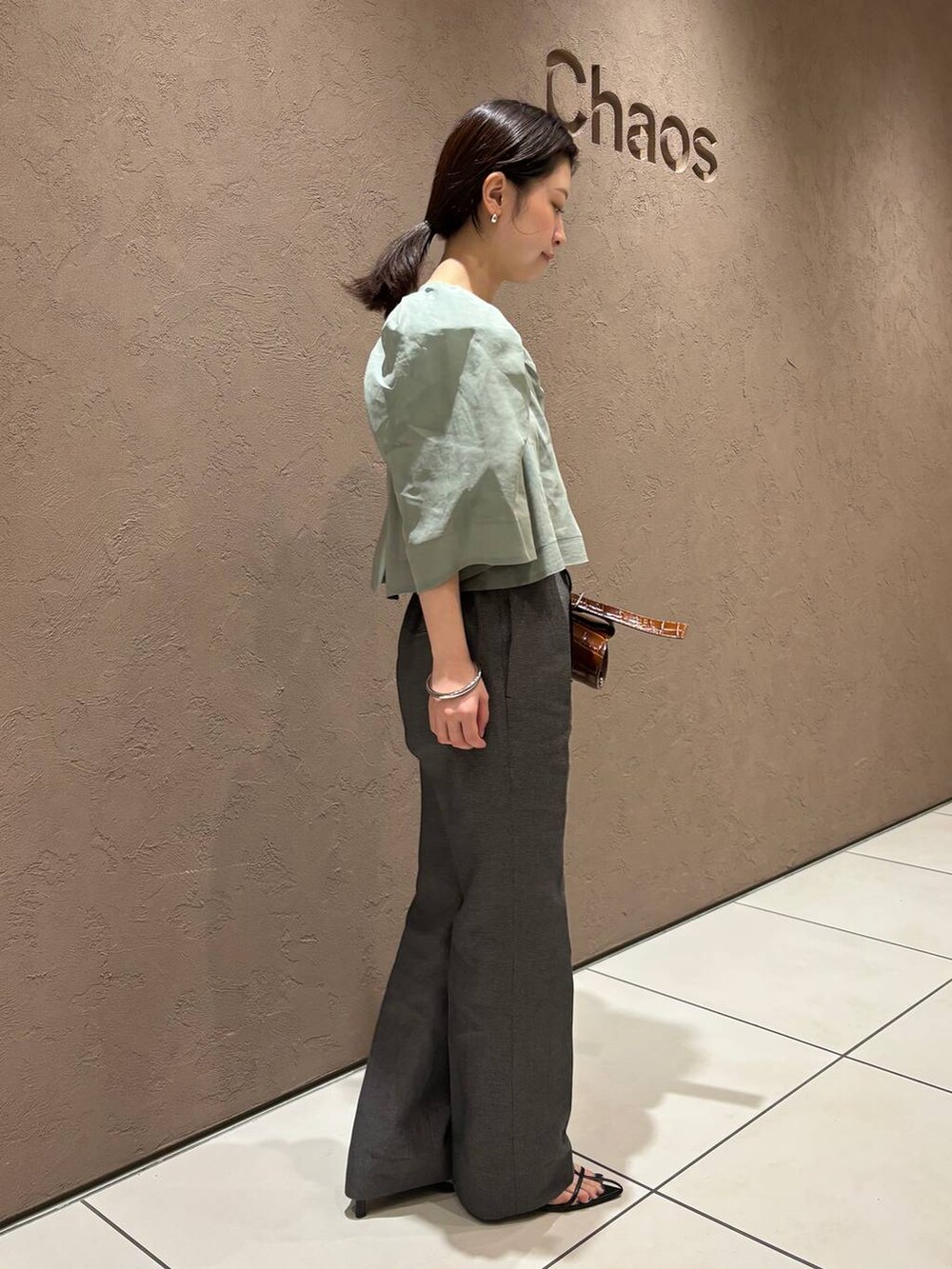 ブラック系のその他パンツ、グリーン系のシャツ/ブラウスを着用したレディースの春コーディネートの2枚目の写真