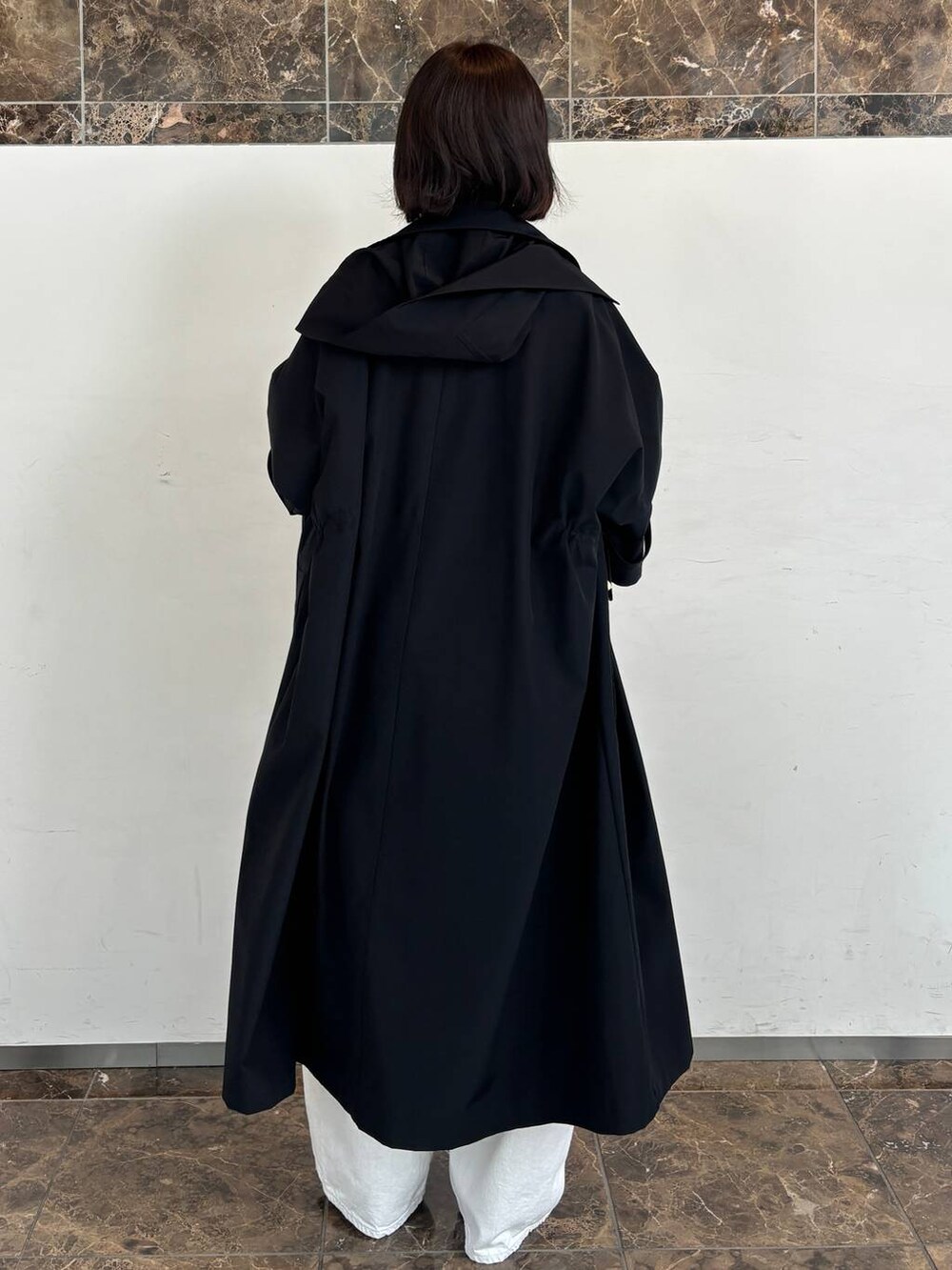 ホワイト系のデニムパンツ、レッド系のTシャツ/カットソー、ブルー系のトレンチコートを着用したレディースの秋コーディネートの3枚目の写真
