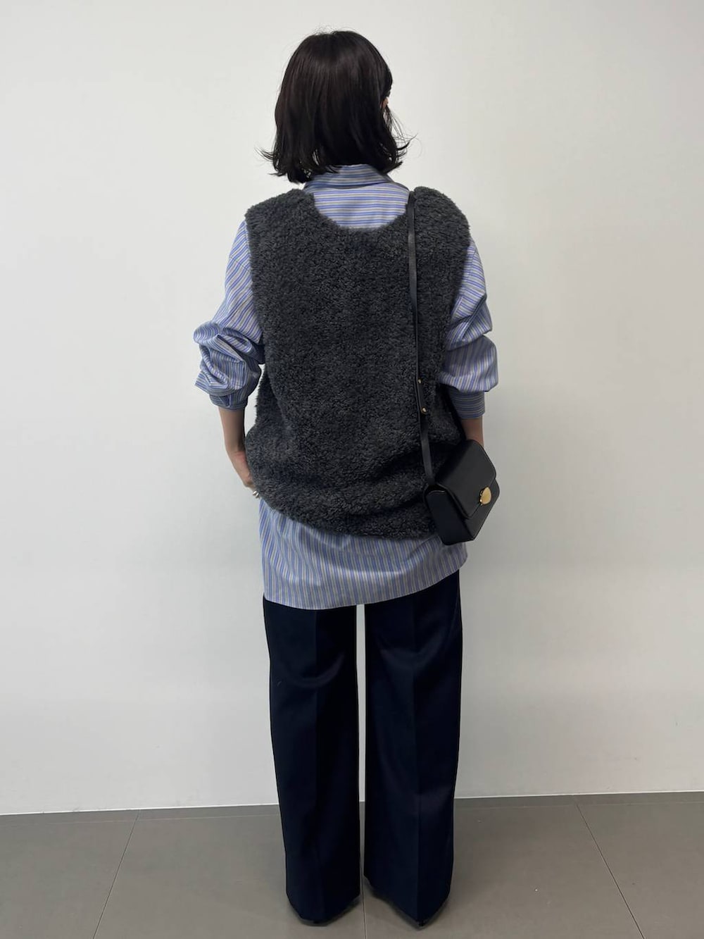 グレー系のベスト、ブルー系のシャツ/ブラウスを着用したレディースの秋コーディネートの3枚目の写真
