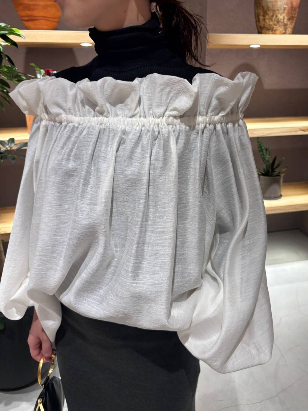 ブラック系のニット/セーター、グリーン系のスカートを着用したレディースの秋コーディネートの4枚目の写真