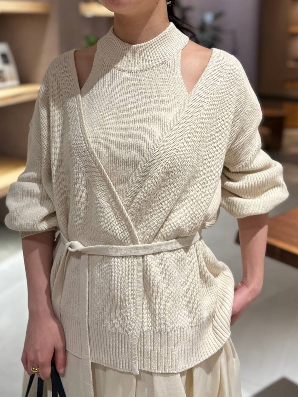 ホワイト系のカーディガン/ボレロ、ホワイト系のタンクトップ、ホワイト系のスカートを着用したレディースの冬コーディネートの9枚目の写真