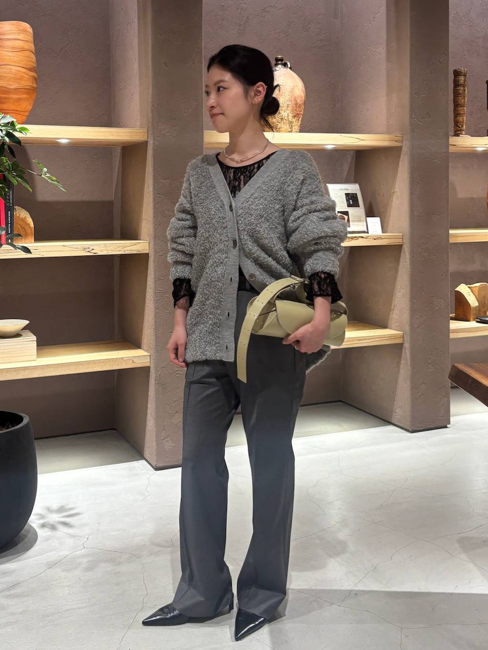 グレー系のカーディガン/ボレロ、ブラック系のTシャツ/カットソー、グレー系のスラックスを着用したレディースの秋コーディネートの2枚目の写真