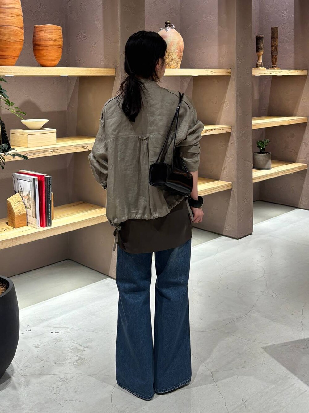 ブラウン系のシャツ/ブラウス、ベージュ系のブルゾン、ブルー系のデニムパンツを着用したレディースの春コーディネートの3枚目の写真