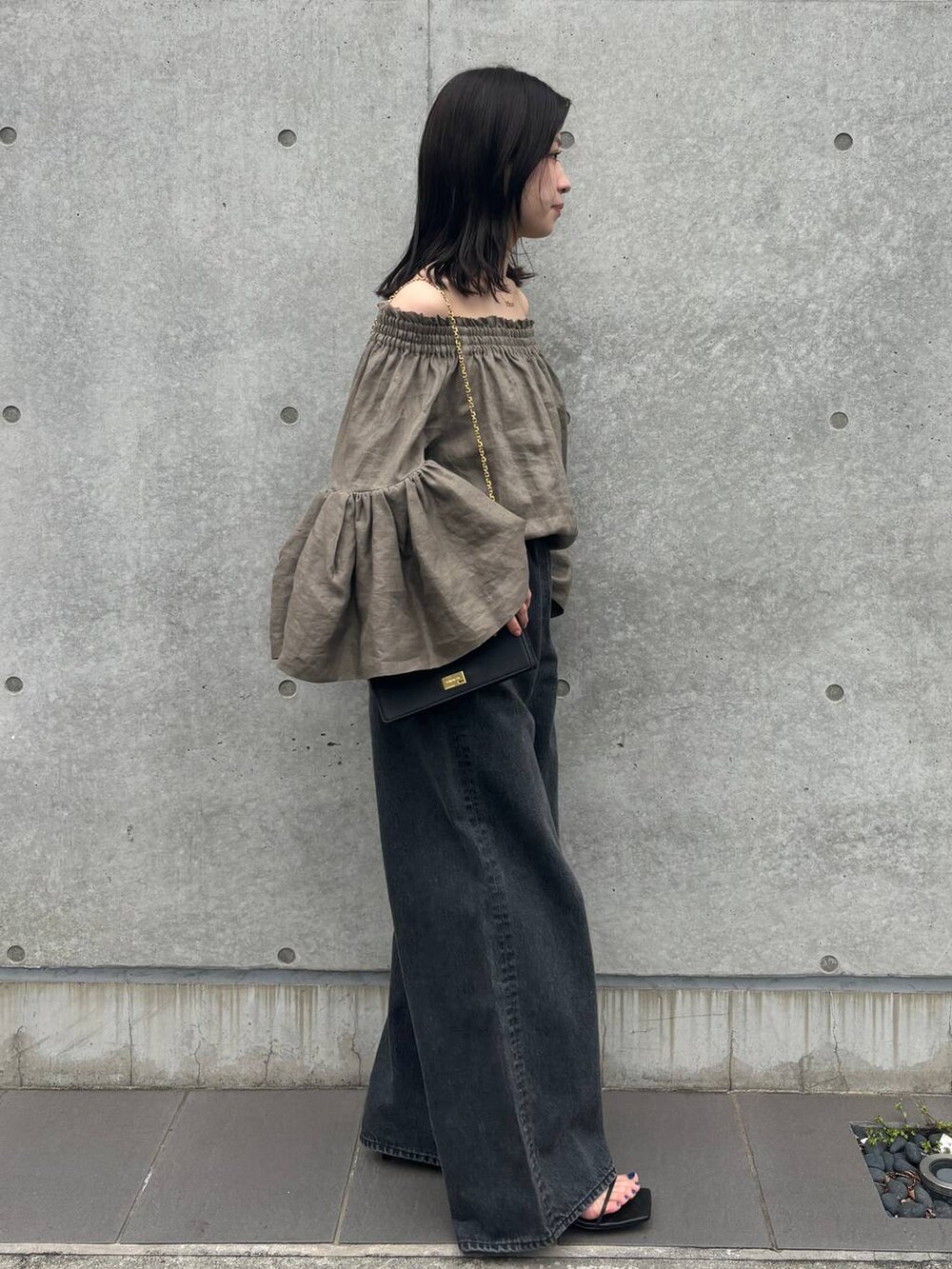 ブラック系のデニムパンツ、グリーン系のシャツ/ブラウスを着用したレディースの春コーディネートの4枚目の写真