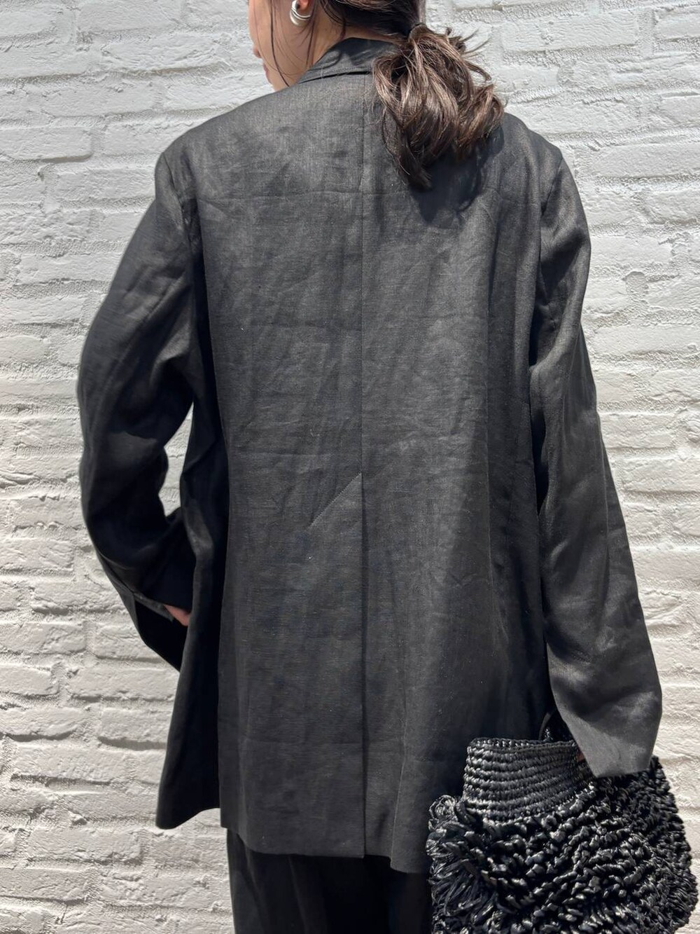 ブラック系のスラックス、ブラック系のテーラードジャケット、ブラウン系のTシャツ/カットソーを着用したレディースの春コーディネートの8枚目の写真