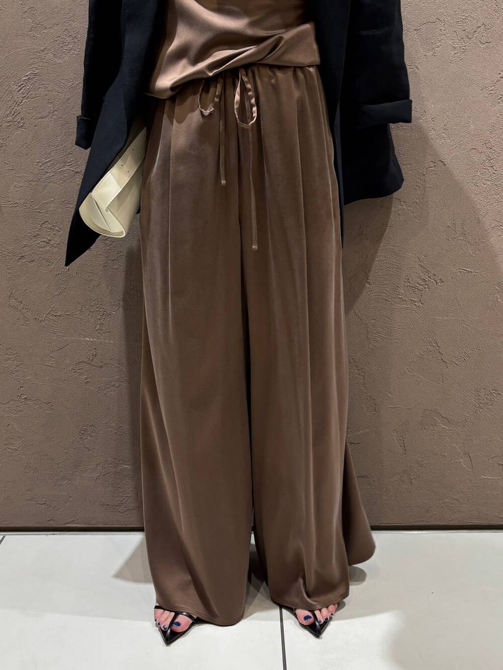 ブラウン系のその他パンツ、ブラウン系のTシャツ/カットソー、ブラック系のテーラードジャケットを着用したレディースの夏コーディネートの5枚目の写真