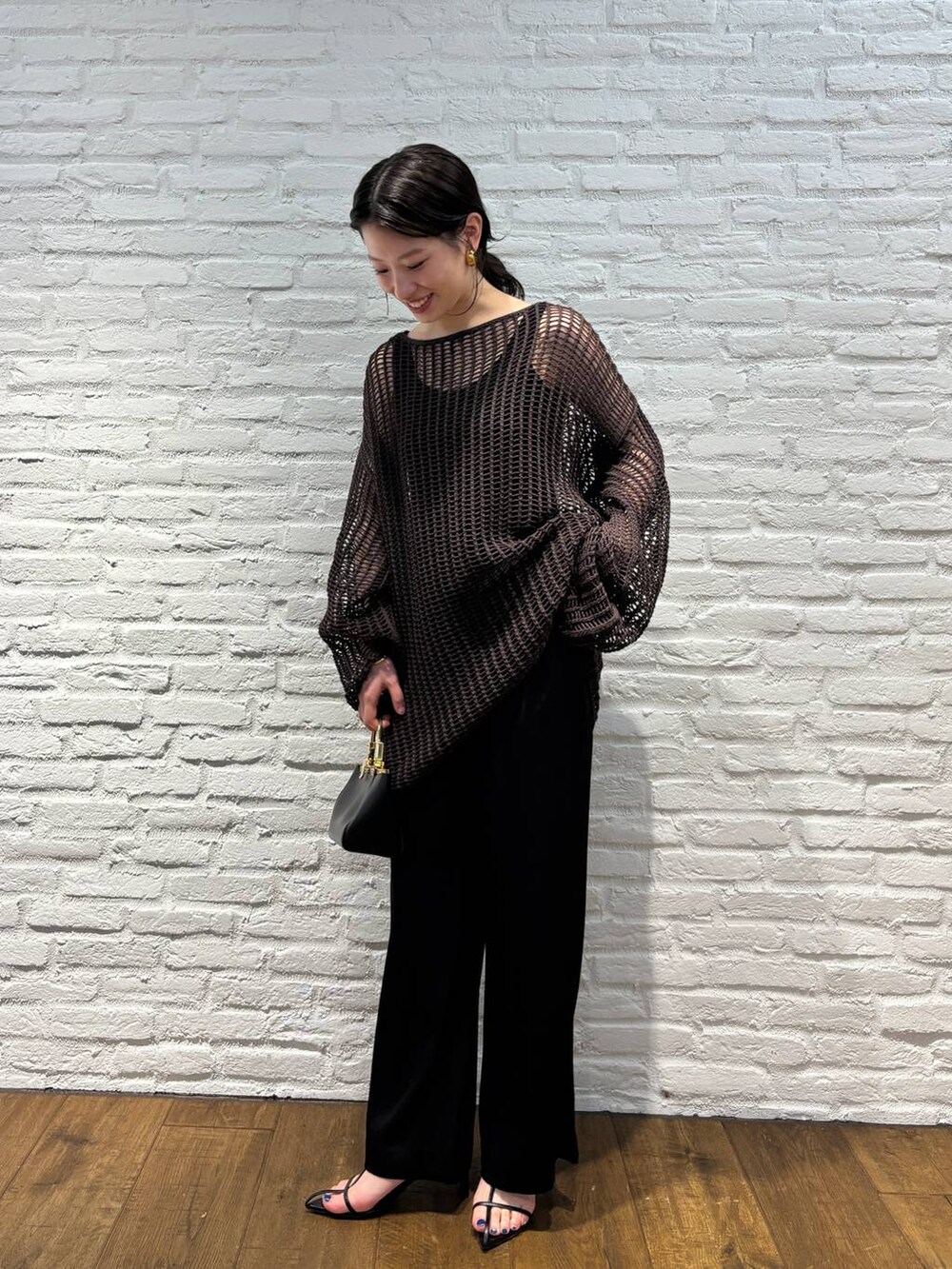 ブラック系のその他パンツ、ブラック系のタンクトップ、ブラウン系のニット/セーターを着用したレディースの春コーディネートの2枚目の写真