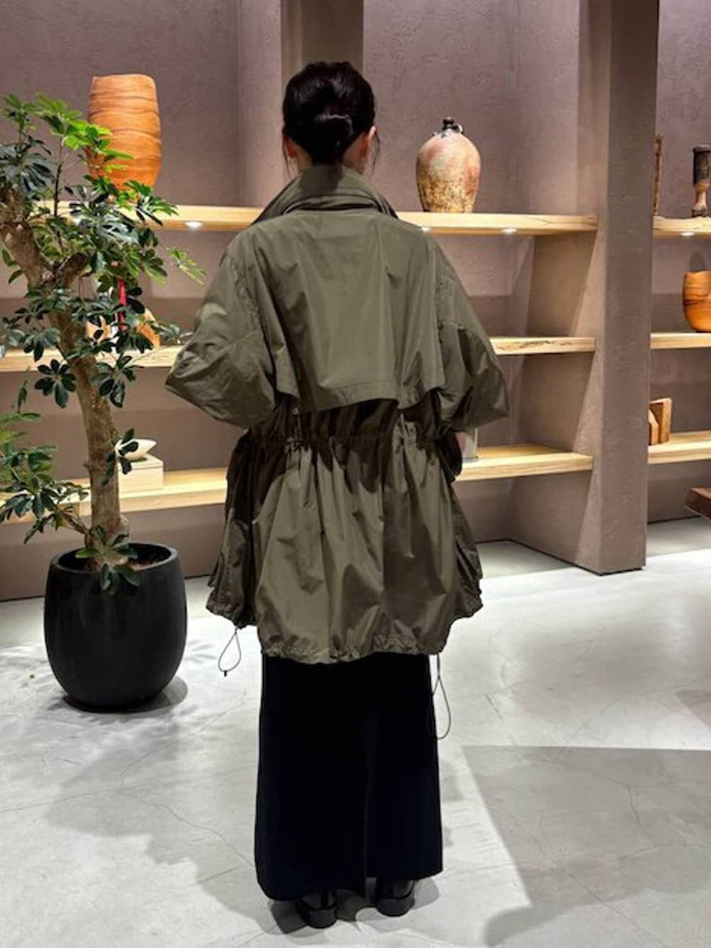 ブラック系のニット/セーター、グリーン系のブルゾン、ブラック系のスカートを着用したレディースの秋コーディネートの4枚目の写真