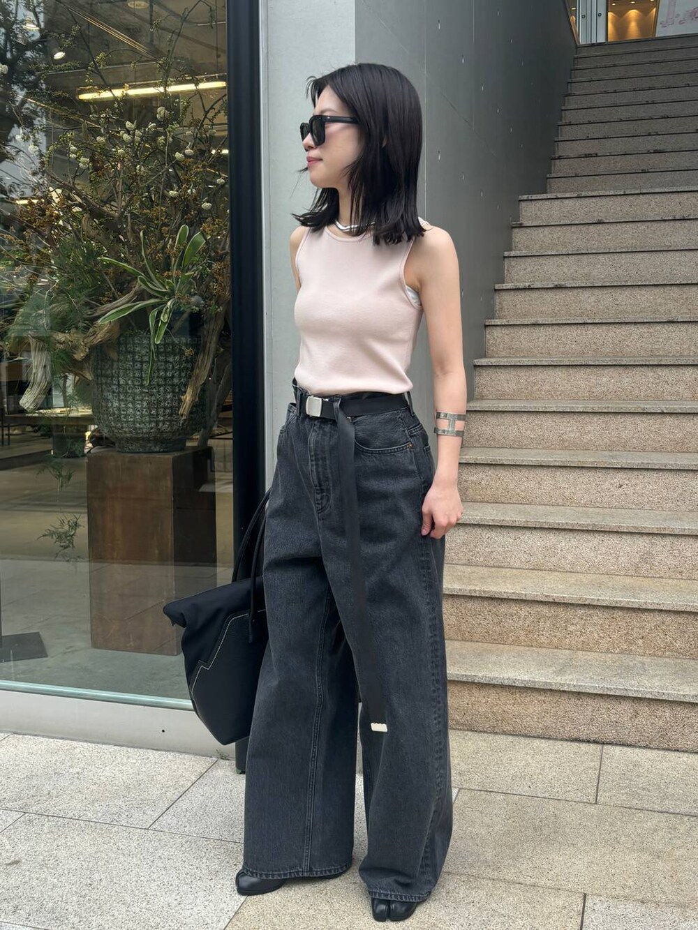 ピンク系のニット/セーター、ブラック系のデニムパンツを着用したレディースの春コーディネートの3枚目の写真