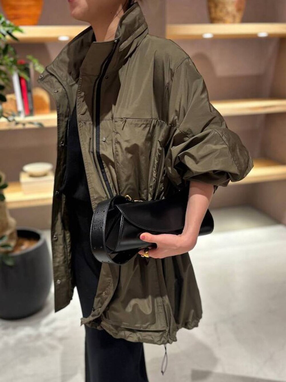 ブラック系のニット/セーター、グリーン系のブルゾン、ブラック系のスカートを着用したレディースの秋コーディネートの6枚目の写真