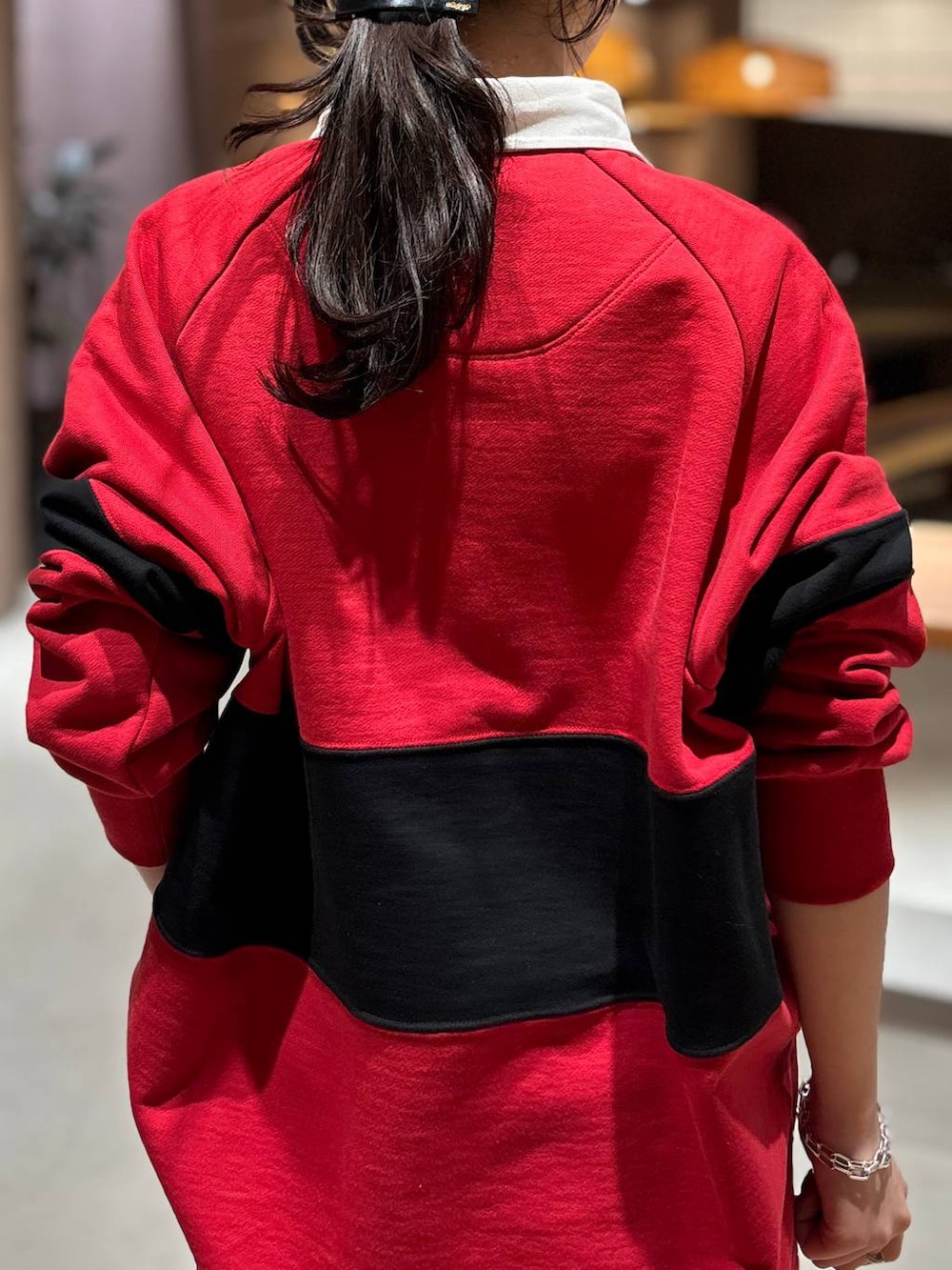 レッド系のスウェット、ベージュ系のトレンチコートを着用したレディースの冬コーディネートの9枚目の写真