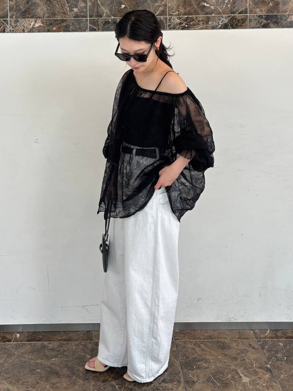 ホワイト系のデニムパンツ、ブラック系のTシャツ/カットソーを着用したレディースの夏コーディネートの2枚目の写真