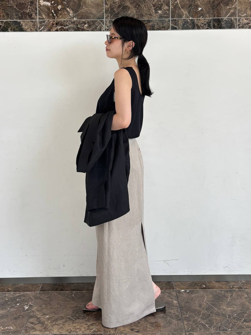ブラック系のシャツ/ブラウス、ホワイト系のスカートを着用したレディースの夏コーディネートの2枚目の写真