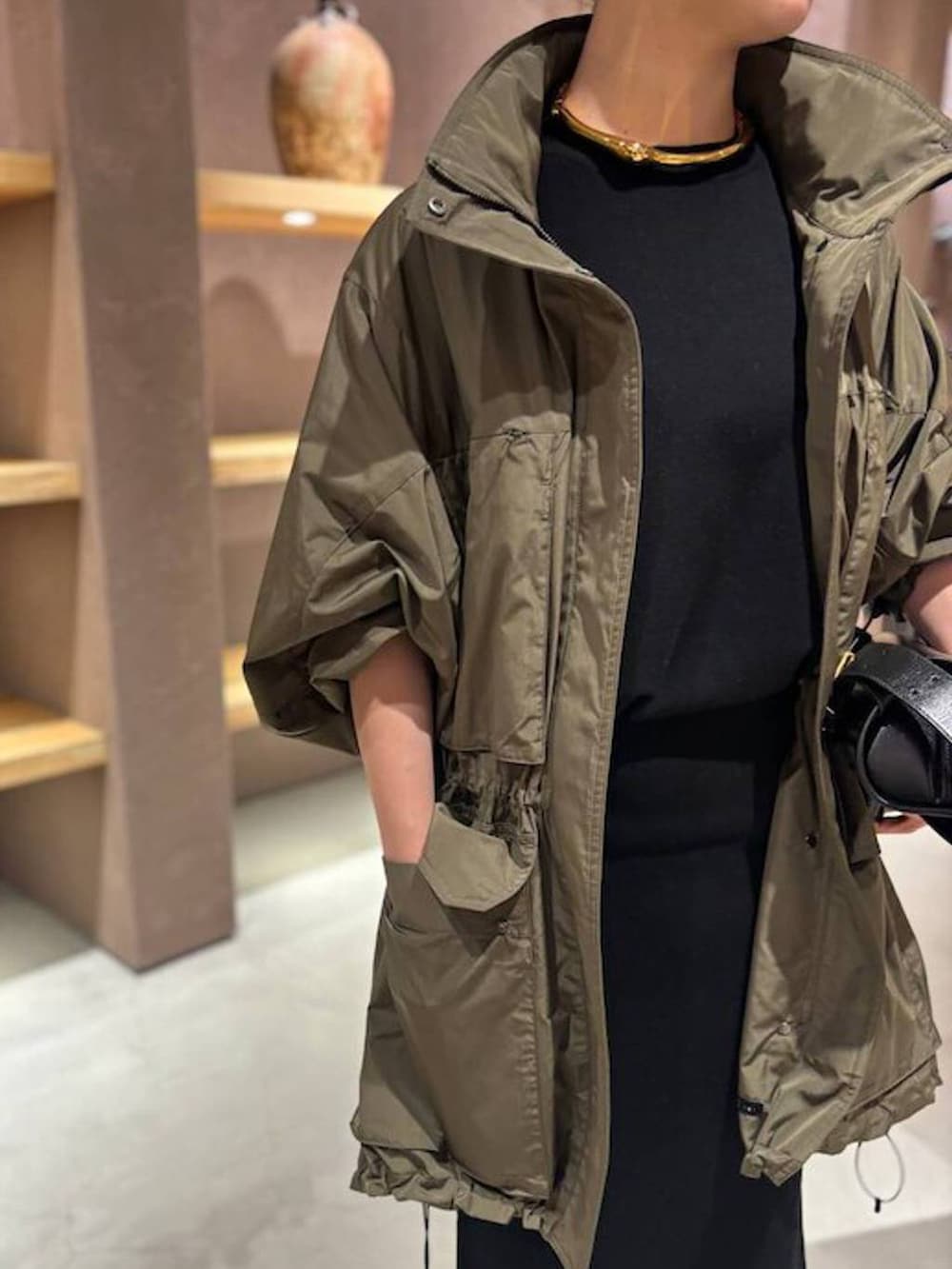 ブラック系のニット/セーター、グリーン系のブルゾン、ブラック系のスカートを着用したレディースの秋コーディネートの5枚目の写真