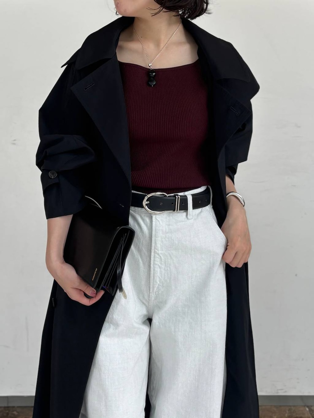 ホワイト系のデニムパンツ、レッド系のTシャツ/カットソー、ブルー系のトレンチコートを着用したレディースの秋コーディネートの4枚目の写真