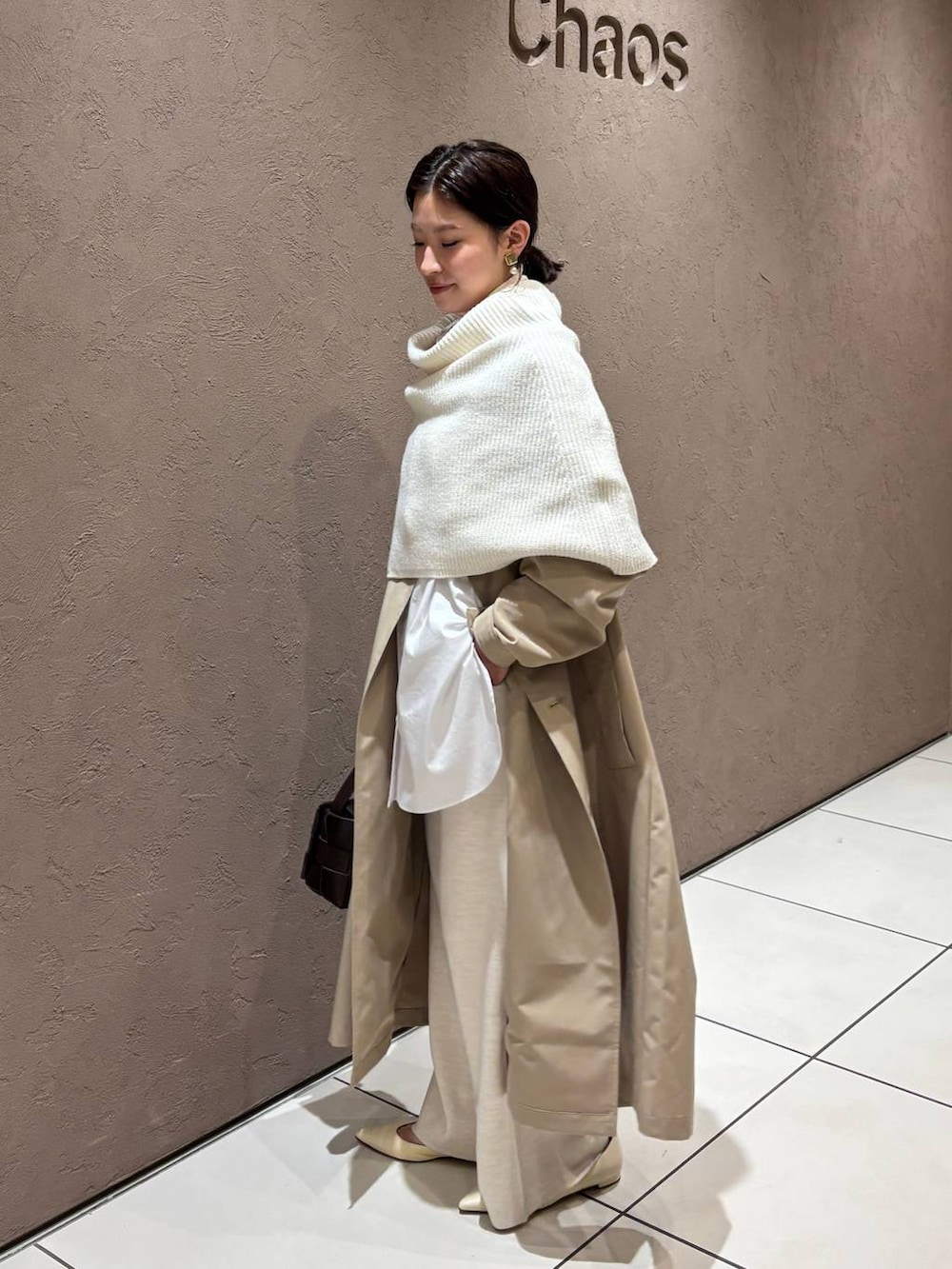 ホワイト系のその他パンツ、ベージュ系のトレンチコート、ホワイト系のストール/ショールを着用したレディースの秋コーディネートの2枚目の写真