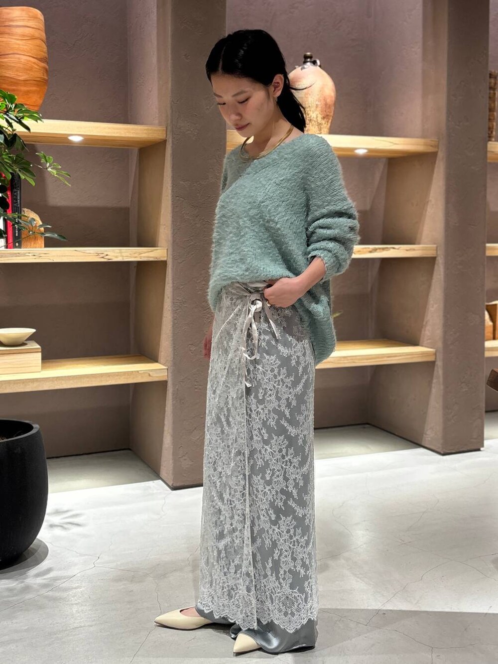 グレー系のスカート、グリーン系のニット/セーター、グリーン系のその他パンツを着用したレディースの秋コーディネートの5枚目の写真