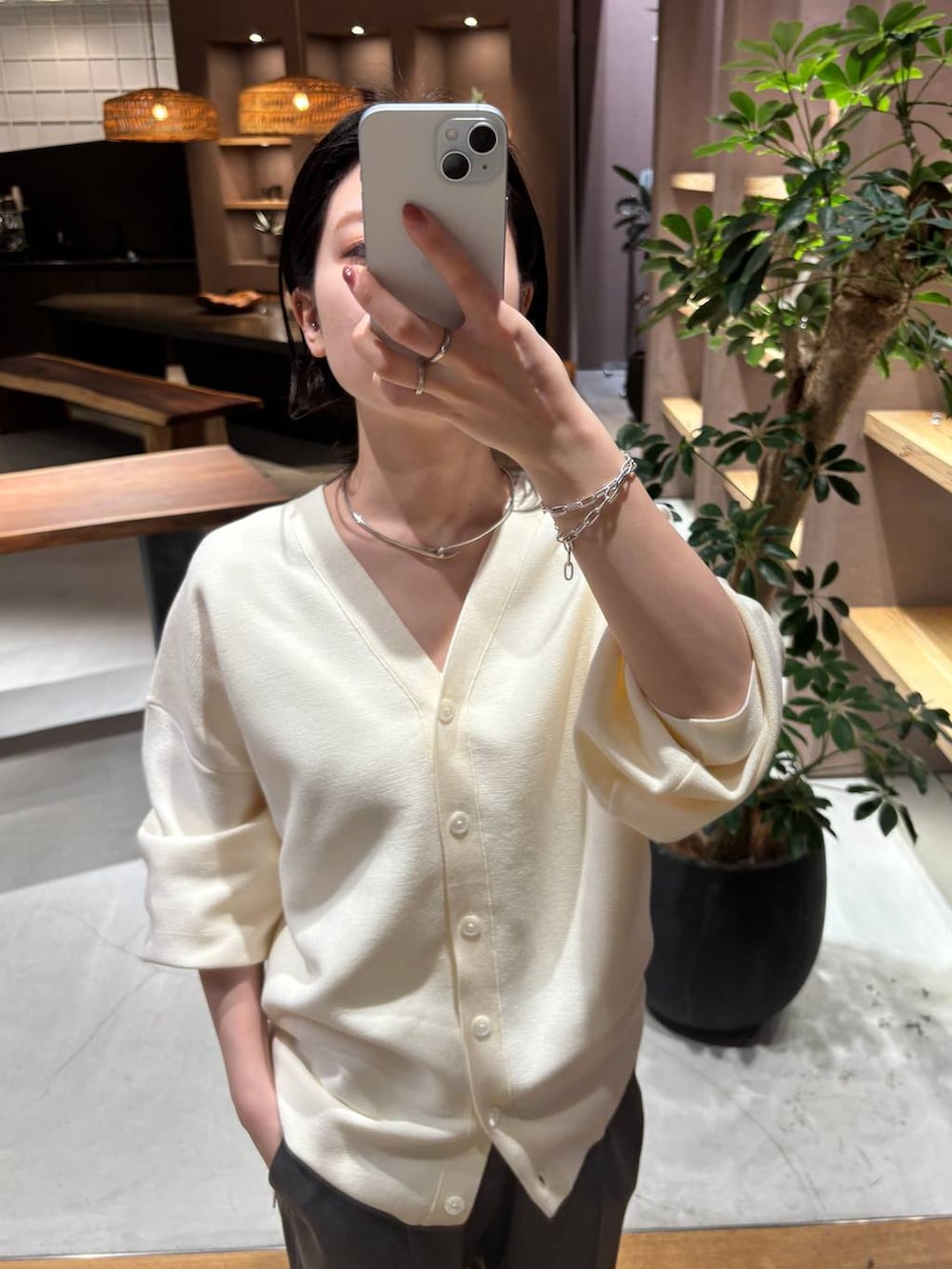 グレー系のスラックス、ホワイト系のカーディガン/ボレロ、ブラック系のトレンチコートを着用したレディースの冬コーディネートの6枚目の写真