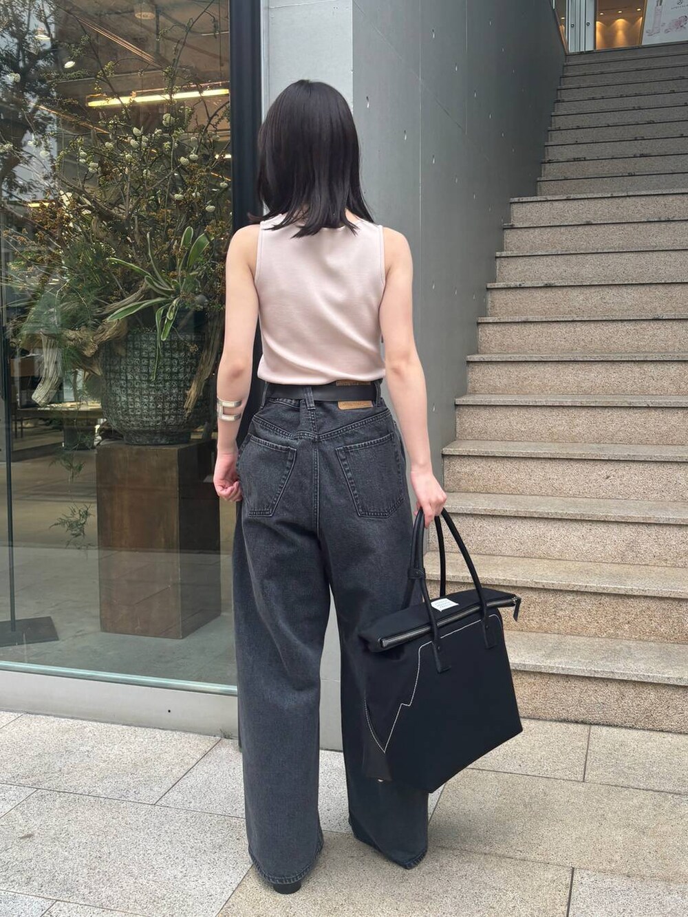 ピンク系のニット/セーター、ブラック系のデニムパンツを着用したレディースの春コーディネートの5枚目の写真