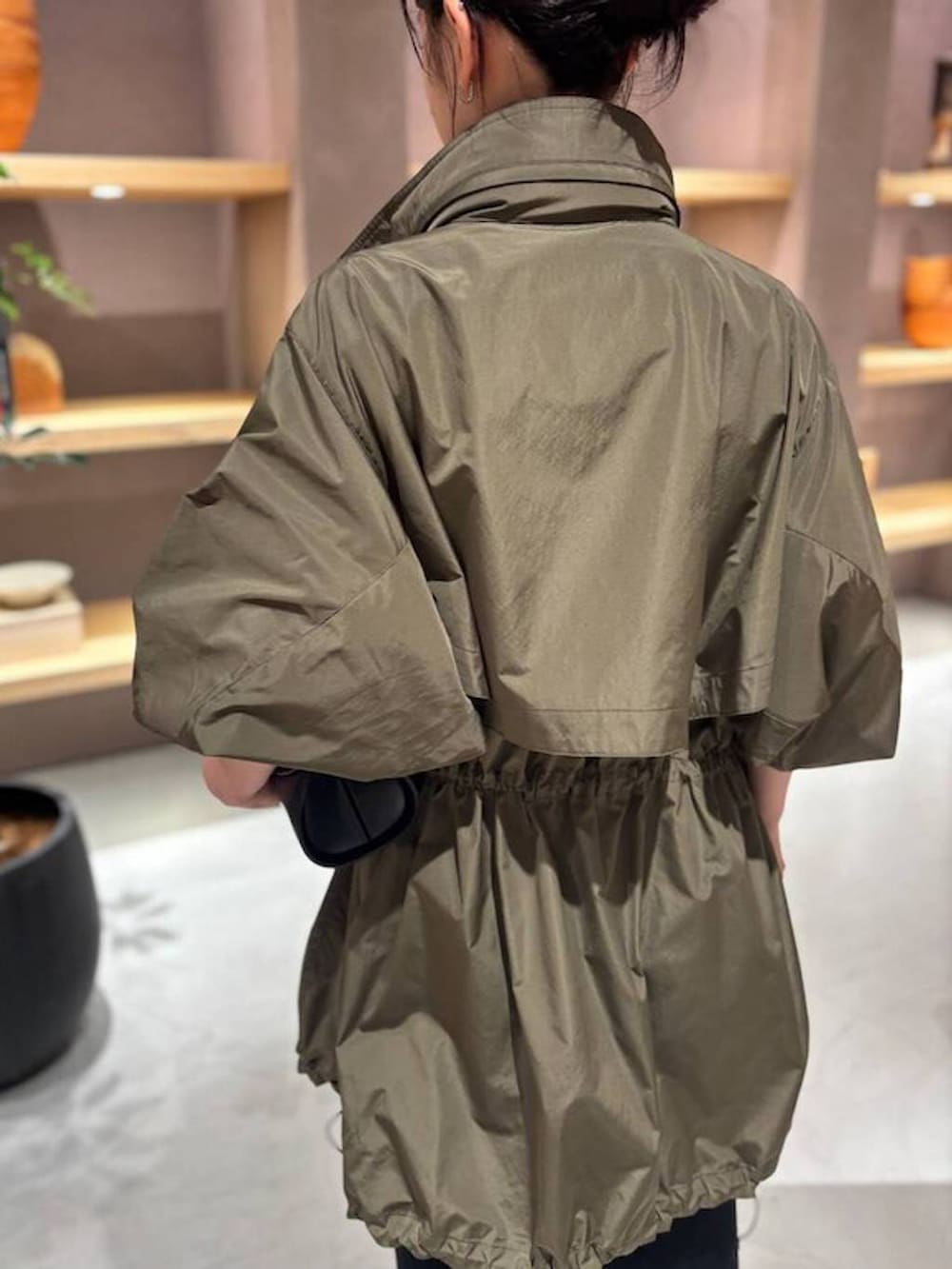 ブラック系のニット/セーター、グリーン系のブルゾン、ブラック系のスカートを着用したレディースの秋コーディネートの7枚目の写真