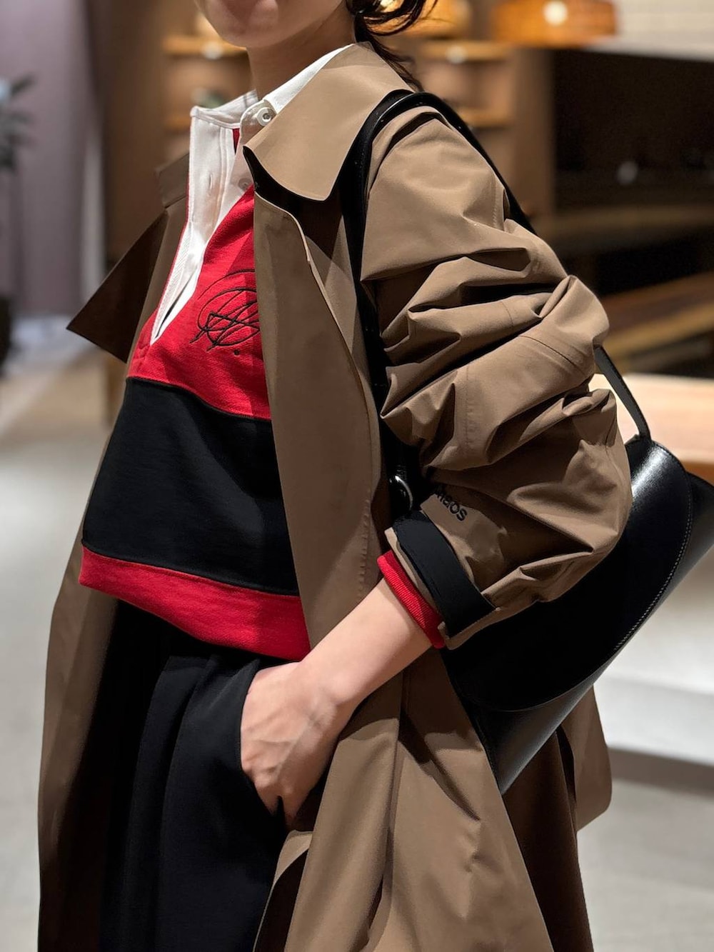 レッド系のスウェット、ベージュ系のトレンチコートを着用したレディースの冬コーディネートの4枚目の写真