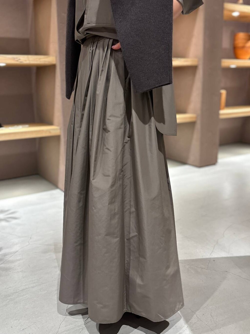 グレー系のニット/セーター、ブラウン系のシャツ/ブラウス、ブラウン系のスカートを着用したレディースの秋コーディネートの8枚目の写真