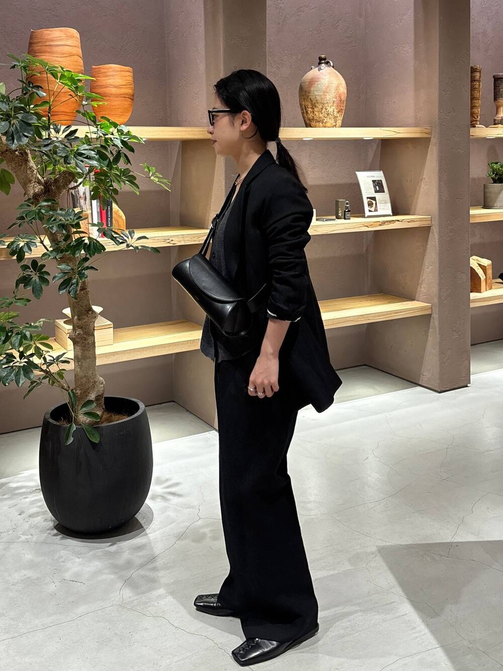 ブラック系のスラックス、ブラック系のテーラードジャケット、グレー系のカーディガン/ボレロを着用したレディースの冬コーディネートの3枚目の写真