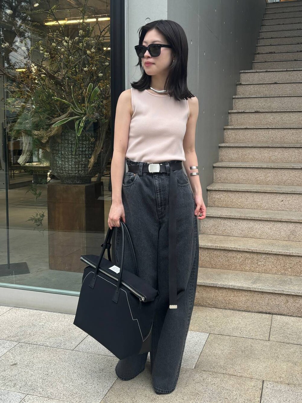 ピンク系のニット/セーター、ブラック系のデニムパンツを着用したレディースの春コーディネートの2枚目の写真