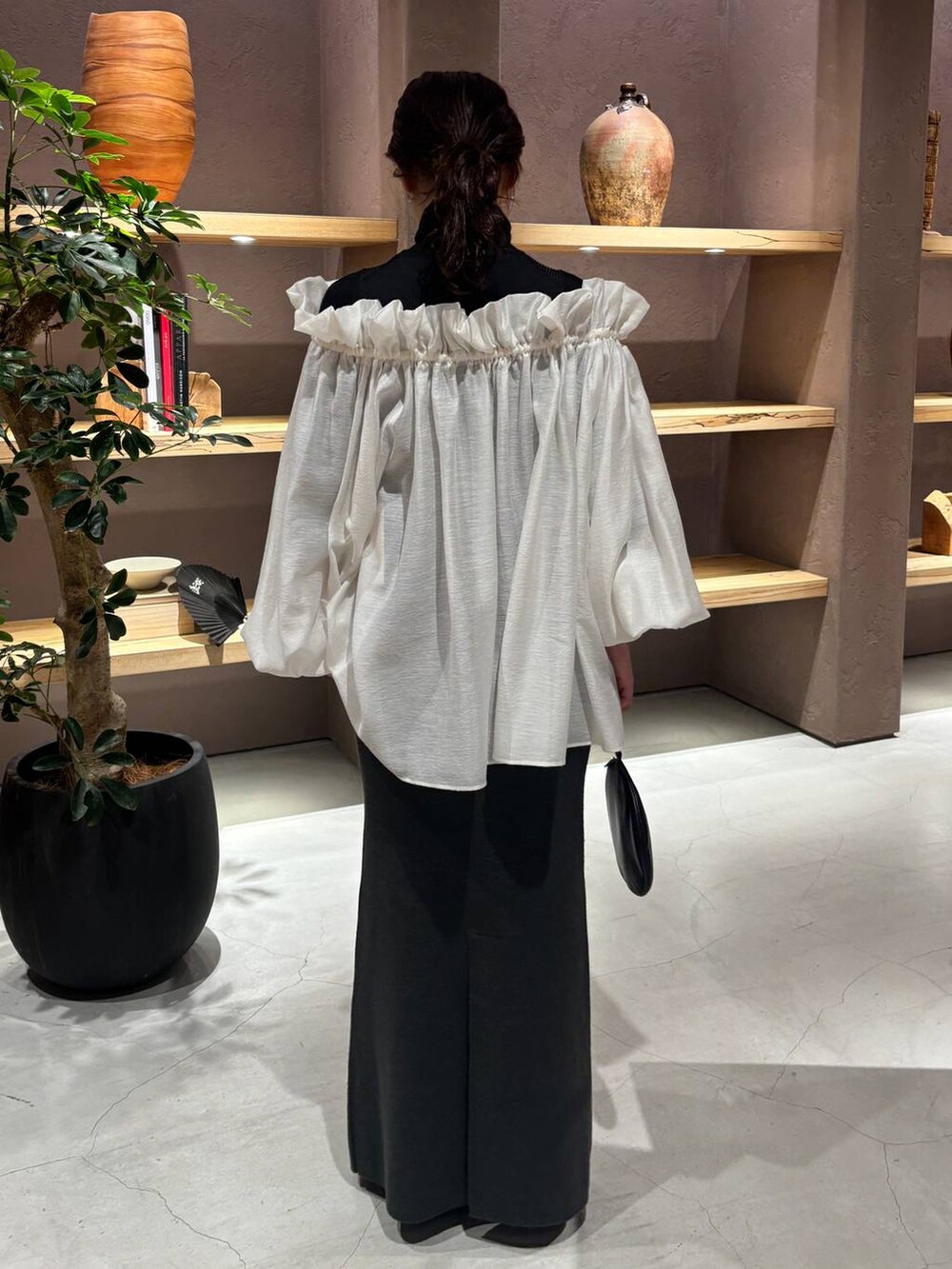 ブラック系のニット/セーター、グリーン系のスカートを着用したレディースの秋コーディネートの3枚目の写真