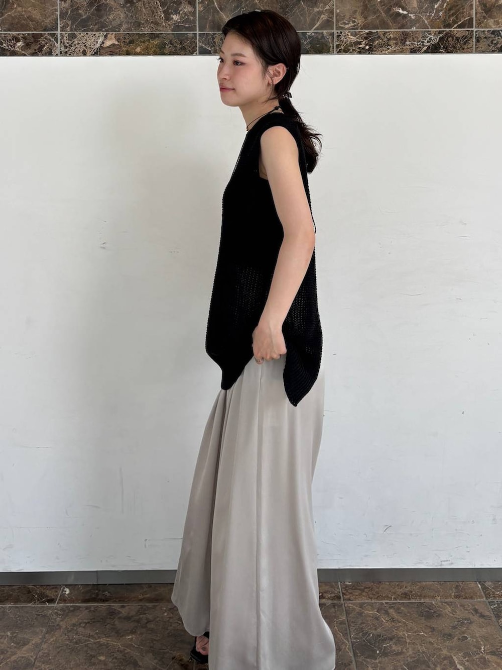 グレー系のその他パンツ、ブラック系のニット/セーターを着用したレディースの夏コーディネートの2枚目の写真