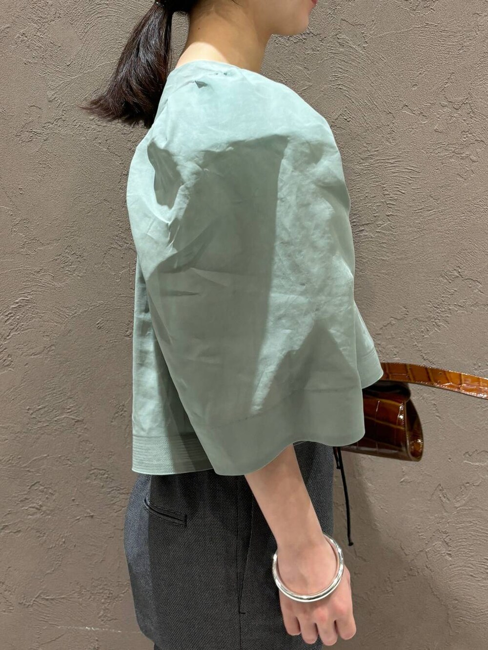 ブラック系のその他パンツ、グリーン系のシャツ/ブラウスを着用したレディースの春コーディネートの5枚目の写真