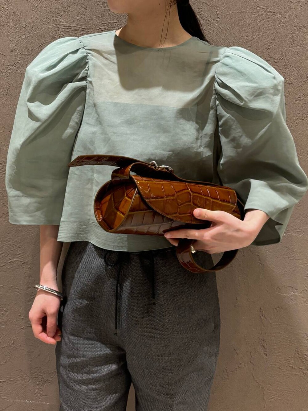 ブラック系のその他パンツ、グリーン系のシャツ/ブラウスを着用したレディースの春コーディネートの4枚目の写真