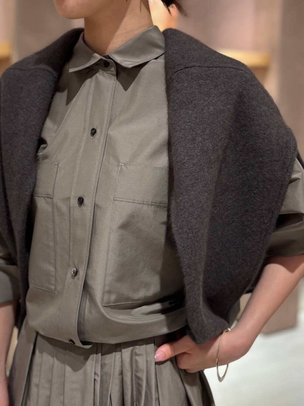 グレー系のニット/セーター、ブラウン系のシャツ/ブラウス、ブラウン系のスカートを着用したレディースの秋コーディネートの4枚目の写真