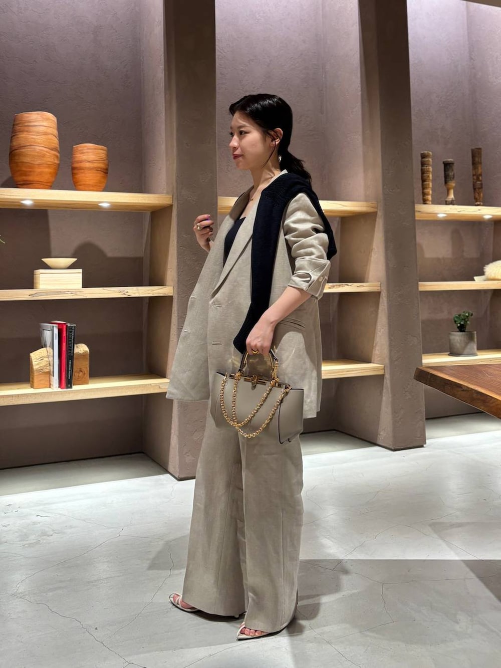 ブルー系のタンクトップ、ブルー系のカーディガン/ボレロ、ベージュ系のテーラードジャケットを着用したレディースの春コーディネートの2枚目の写真