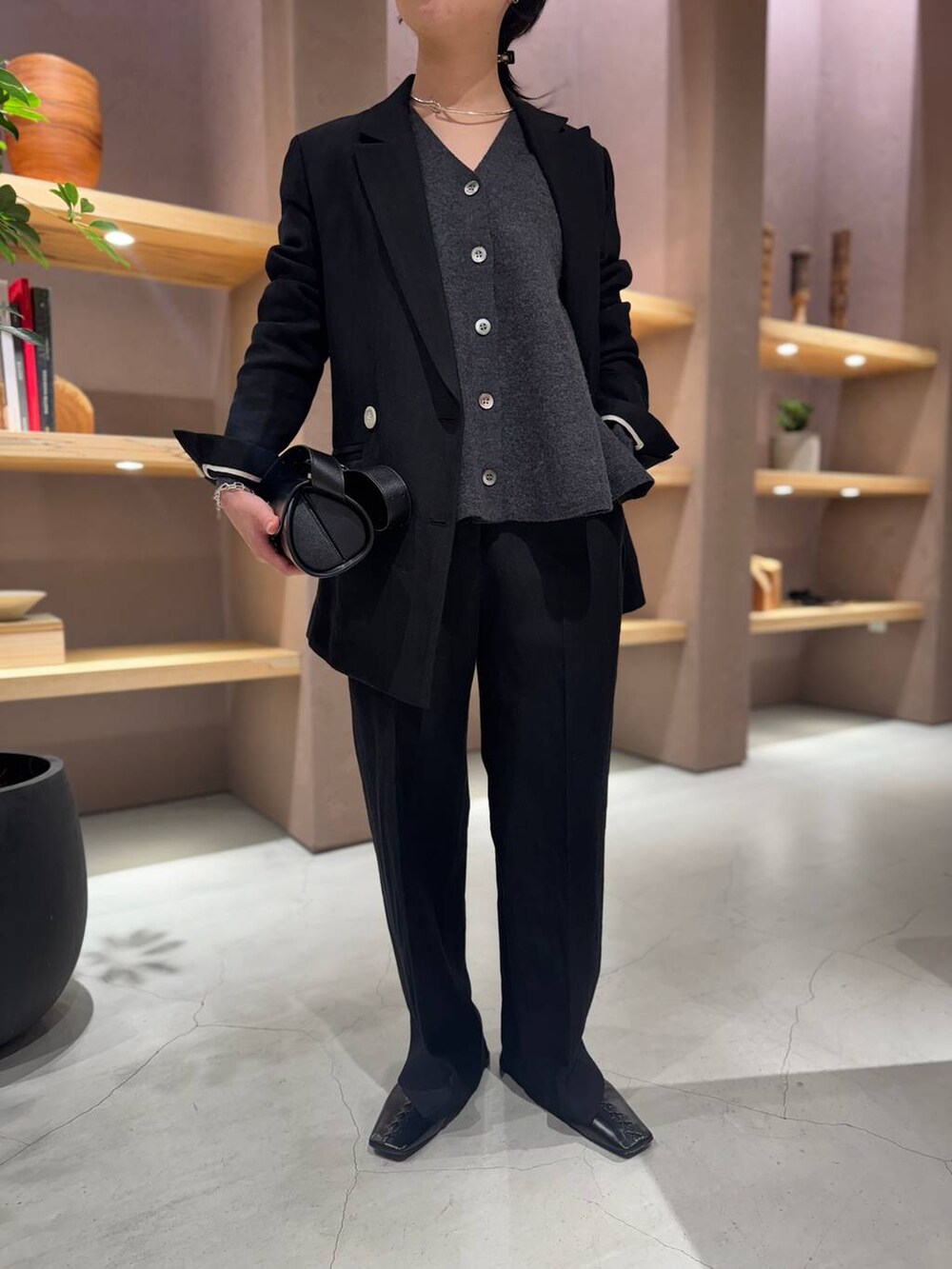 ブラック系のスラックス、ブラック系のテーラードジャケット、グレー系のカーディガン/ボレロを着用したレディースの冬コーディネートの6枚目の写真