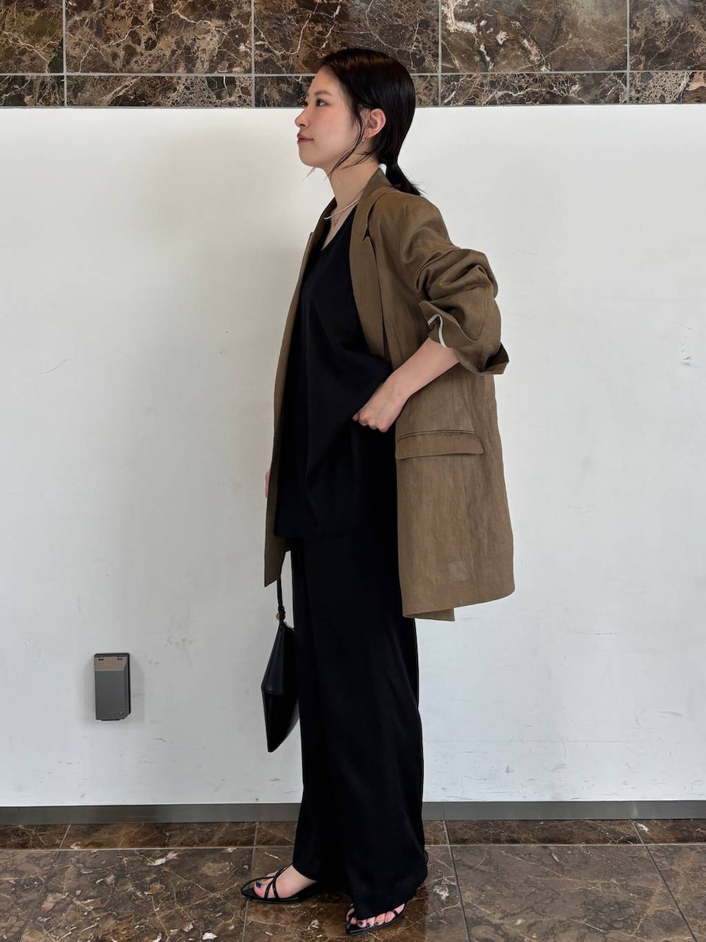 ブラック系のその他パンツ、ブラック系のシャツ/ブラウス、グリーン系のテーラードジャケットを着用したレディースの春コーディネートの2枚目の写真