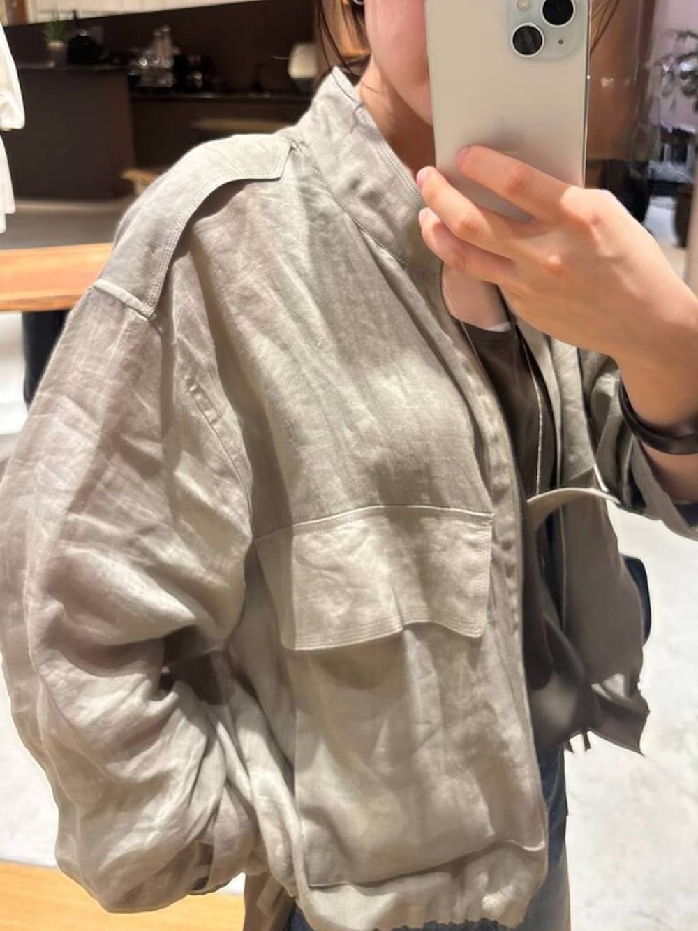 ブラウン系のシャツ/ブラウス、ベージュ系のブルゾン、ブルー系のデニムパンツを着用したレディースの春コーディネートの5枚目の写真