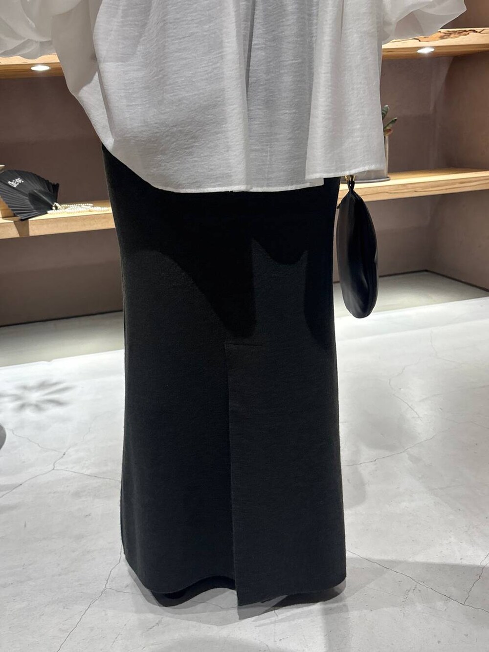 ブラック系のニット/セーター、グリーン系のスカートを着用したレディースの秋コーディネートの9枚目の写真