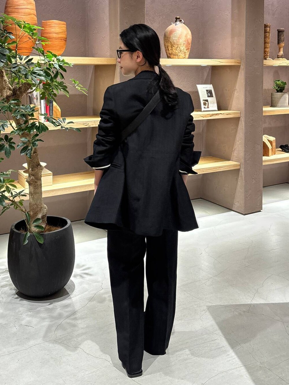 ブラック系のスラックス、ブラック系のテーラードジャケット、グレー系のカーディガン/ボレロを着用したレディースの冬コーディネートの4枚目の写真