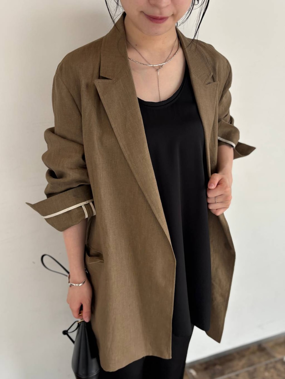 ブラック系のその他パンツ、ブラック系のシャツ/ブラウス、グリーン系のテーラードジャケットを着用したレディースの春コーディネートの4枚目の写真