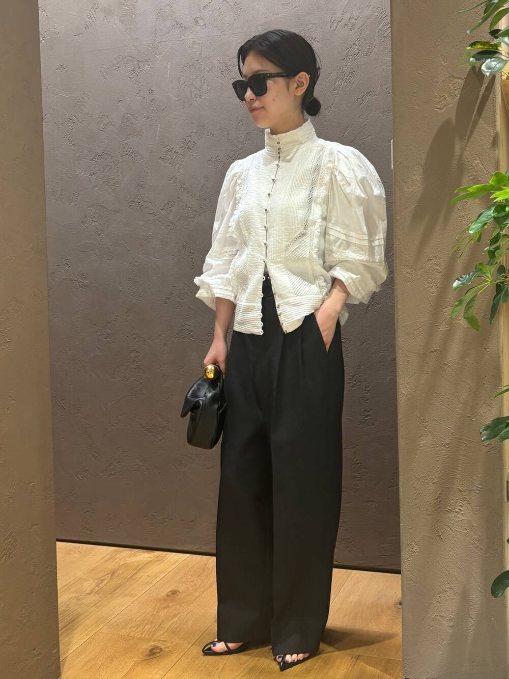 グレー系のスラックス、ホワイト系のシャツ/ブラウスを着用したレディースの春コーディネートの2枚目の写真