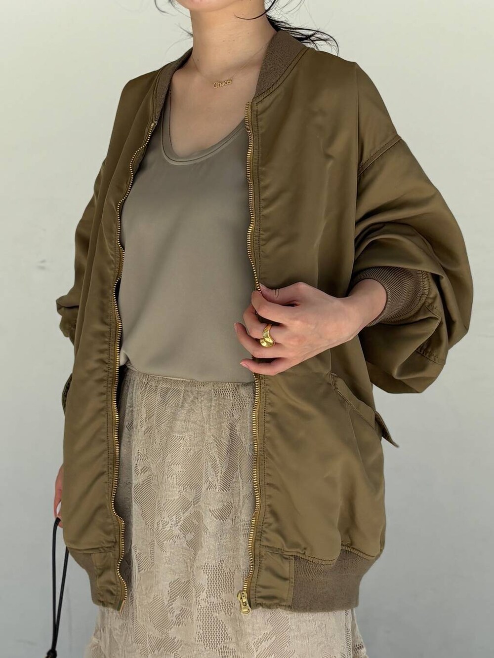 ベージュ系のスカート、グリーン系のMA-1、グレー系のシャツ/ブラウスを着用したレディースの夏コーディネートの5枚目の写真