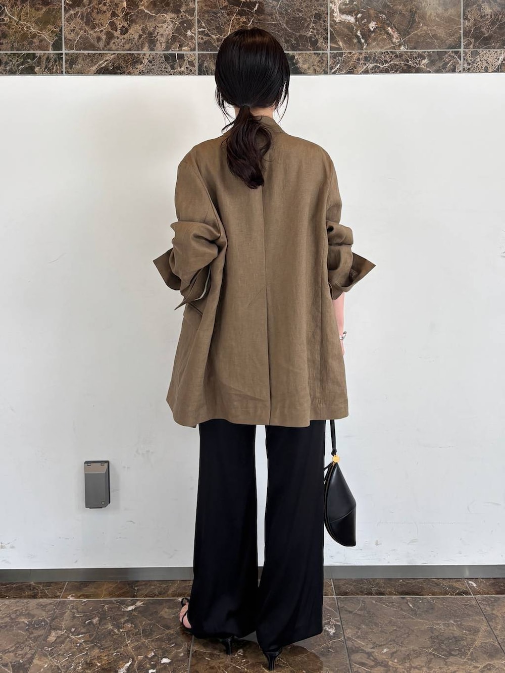 ブラック系のその他パンツ、ブラック系のシャツ/ブラウス、グリーン系のテーラードジャケットを着用したレディースの春コーディネートの3枚目の写真