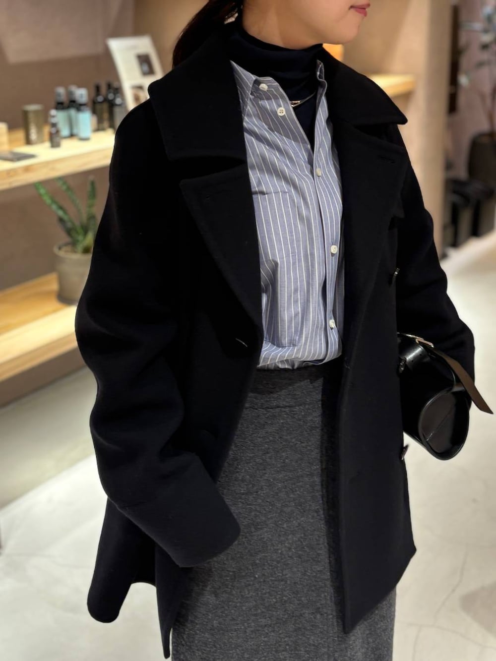 ブルー系のニット/セーター、ブルー系のシャツ/ブラウス、ブルー系のピーコートを着用したレディースの秋コーディネートの7枚目の写真