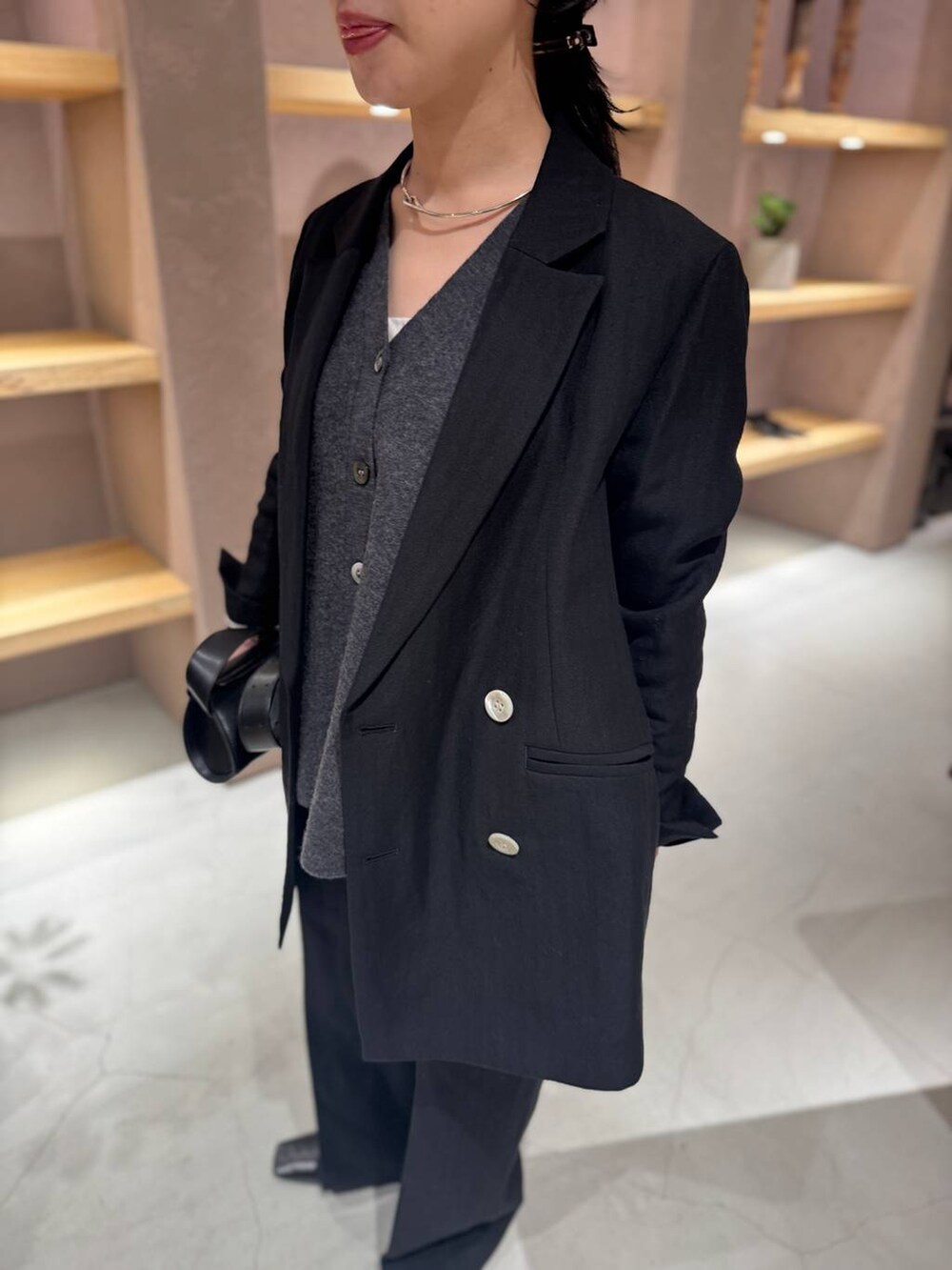 ブラック系のスラックス、ブラック系のテーラードジャケット、グレー系のカーディガン/ボレロを着用したレディースの冬コーディネートの5枚目の写真