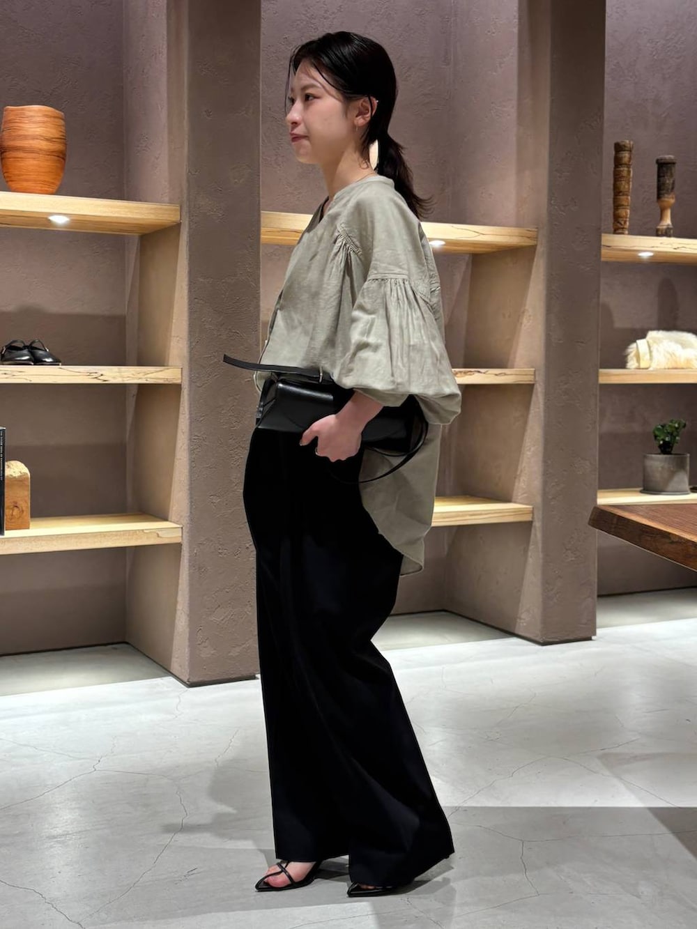 グリーン系のシャツ/ブラウス、ブラック系のスラックスを着用したレディースの春コーディネートの3枚目の写真