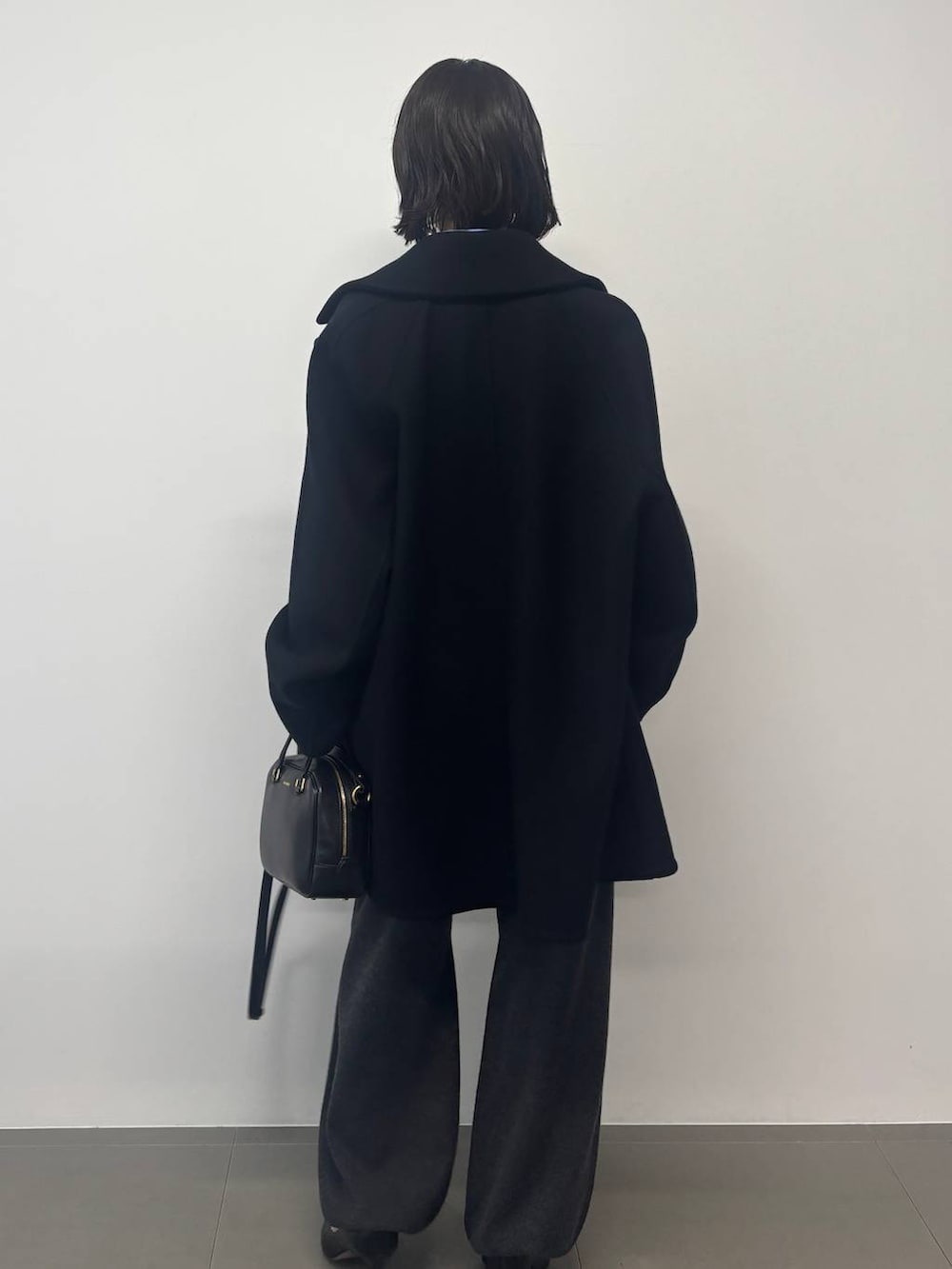 グレー系のその他パンツ、ブラック系のピーコート、グレー系のストール/ショールを着用したレディースの秋コーディネートの3枚目の写真