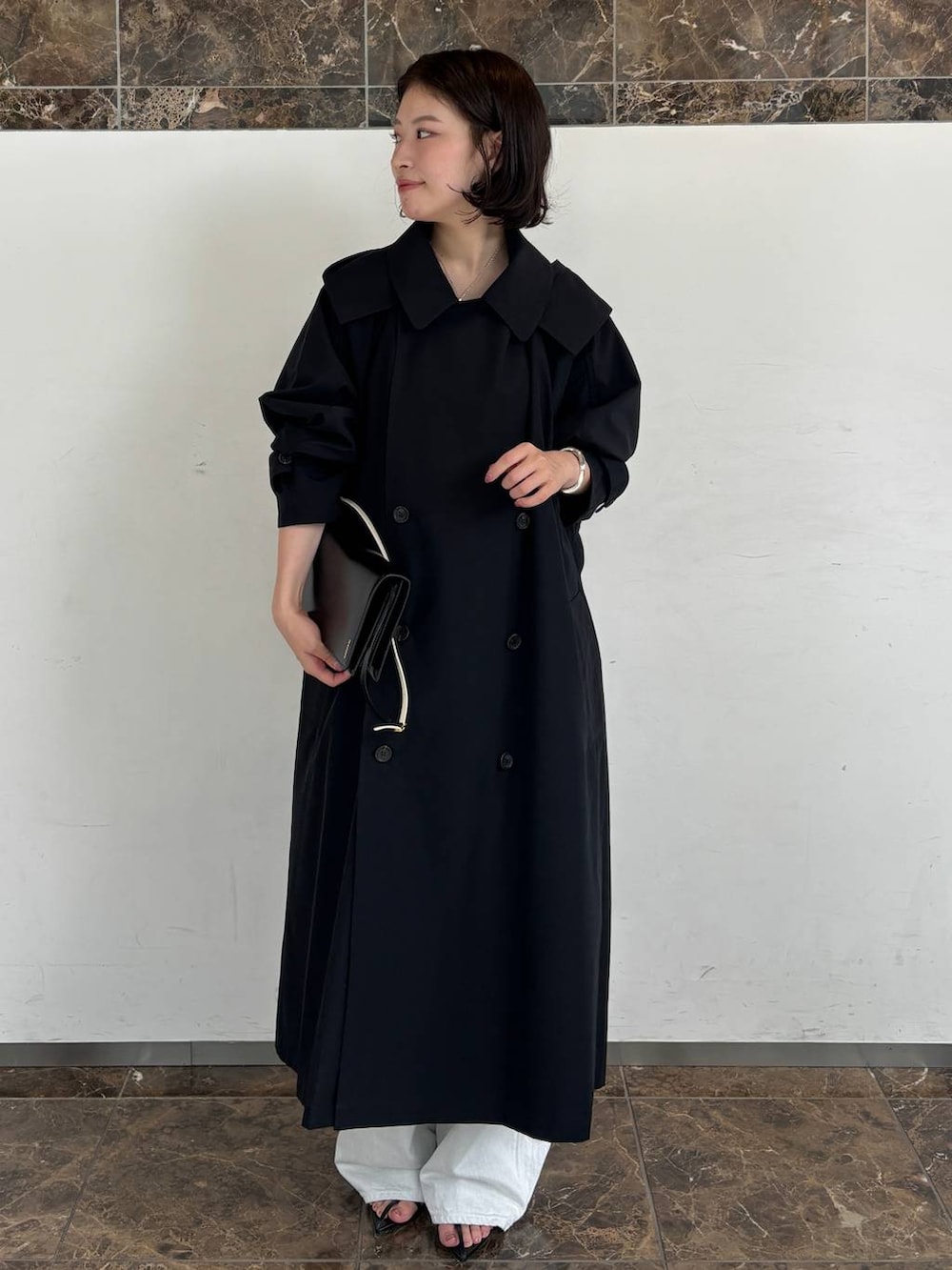 ホワイト系のデニムパンツ、レッド系のTシャツ/カットソー、ブルー系のトレンチコートを着用したレディースの秋コーディネートの6枚目の写真